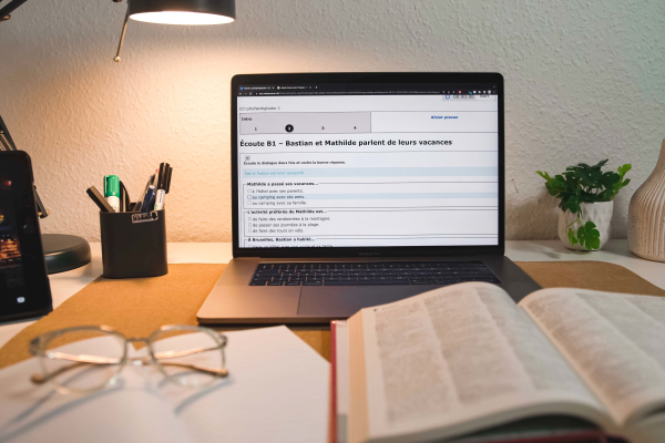 en computer der er tændt og bøger på bordet